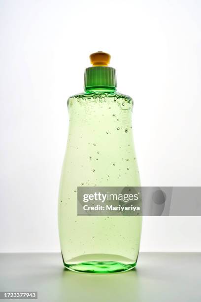 green transparent bottle of dishwashing detergent with bubbles. - tvålpump bildbanksfoton och bilder