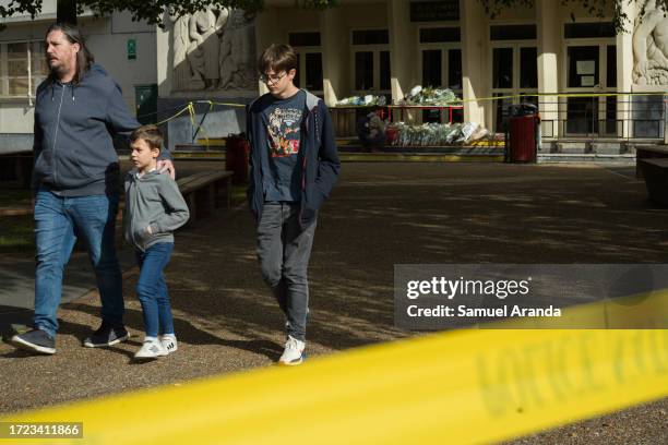 Man and two children leave the Gambetta-Carnot public school where Dominique Bernard, a teacher was fatally stabbed yesterday, on October 14, 2023 in...