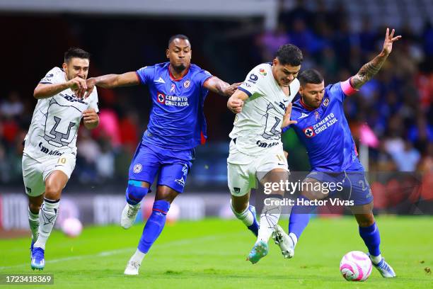 Willer Ditta and Juan Escobar of Cruz Azul battle for possession with Eduardo Salvio and Gabriel Fernández of Pumas UNAM during the 12th round match...