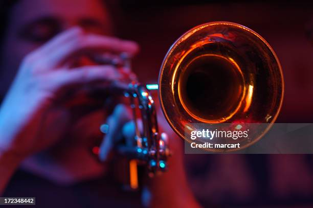 close-up of the cone of a trumpet with player out of focus - trumpet stock pictures, royalty-free photos & images