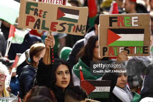 Supporters of Palestine hold placards during a rally to condemn the recent fighting in Gaza on October 14, 2023 in Glasgow, United Kingdom. Groups...