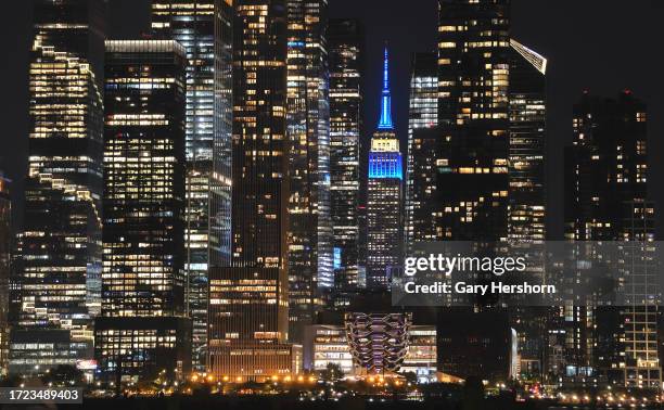 The Empire State Building illuminates in the colors of the flag of Israel in New York City on October 7 as seen from Weehawken, New Jersey.