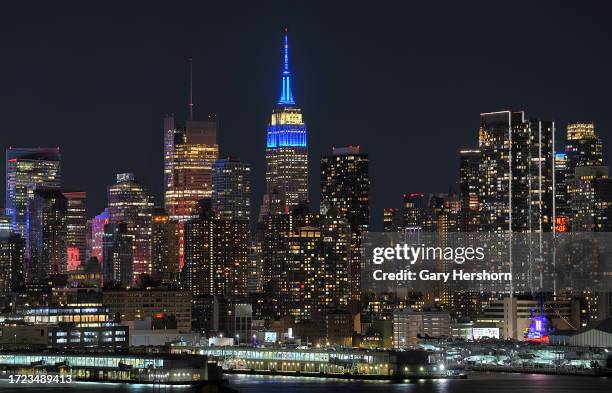 The Empire State Building illuminates in the colors of the flag of Israel in New York City on October 7 as seen from West New York, New Jersey.
