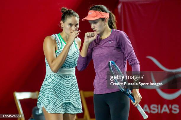 Anna Danilina of Kazakhstan and Alexandra Panova discuss during the women's doubles semi-final match against Oksana Kalashnikova of Georgia and...