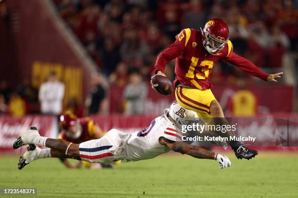 Caleb Williams of the USC Trojans avoids a tackle from Justin Flowe of the Arizona Wildcats during the third quarter at United Airlines Field at the...