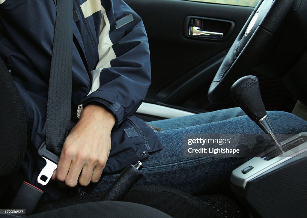 A picture of a man buckling his seat belt