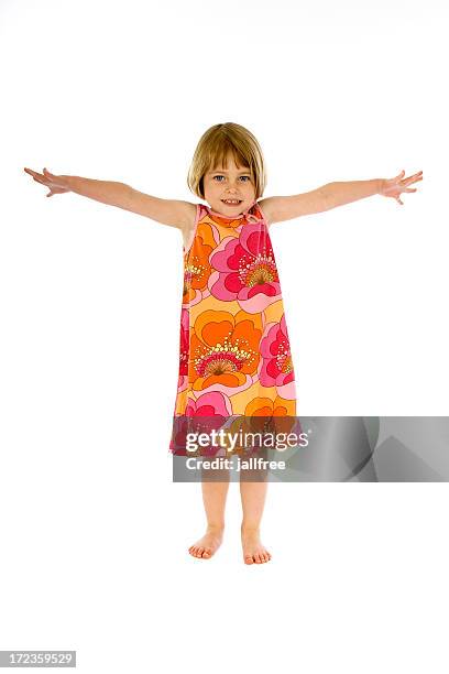 niedliche kleine mädchen in kleid mit armen ausgestreckt - kind ca 3 jahre freigestellt stock-fotos und bilder