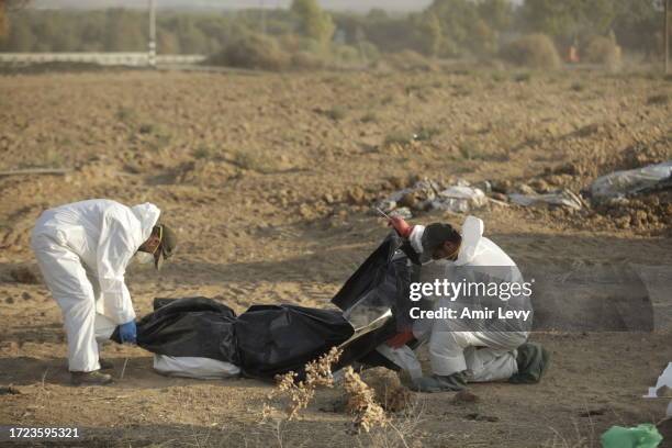 The bodies of Palestinian militants are removed from a kibbutz that was attacked near the border with Gaza on October 14, 2023 in Be’eri, Israel....