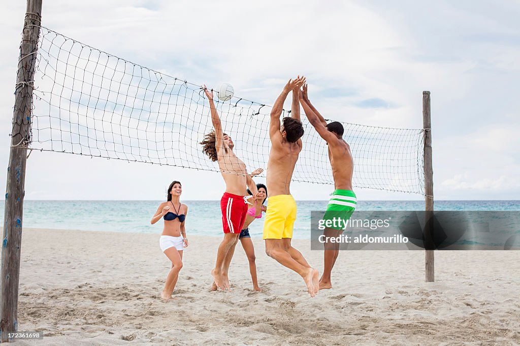 Excited friends playing volleyball