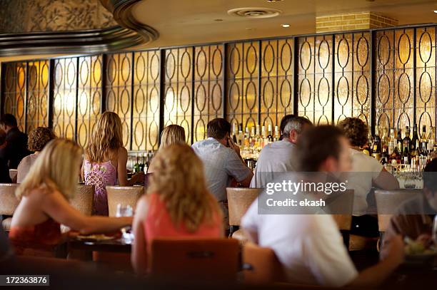 crowded bar in fine restaurant - huddle stock pictures, royalty-free photos & images