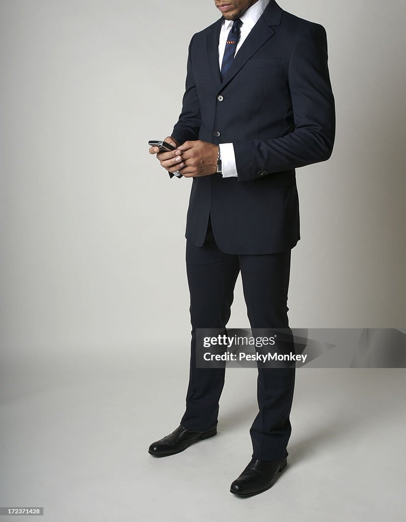 Smartly Dressed African American Businessman Checks His Smartphone