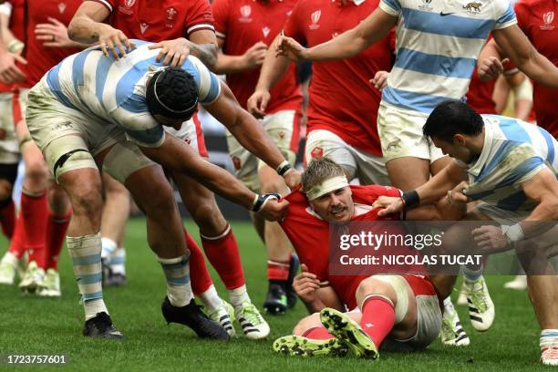 Wales' number eight Aaron Wainwright tussles with Argentina's Argentina's lock Tomas Lavanini and Argentina's left wing Mateo Carreras during the...