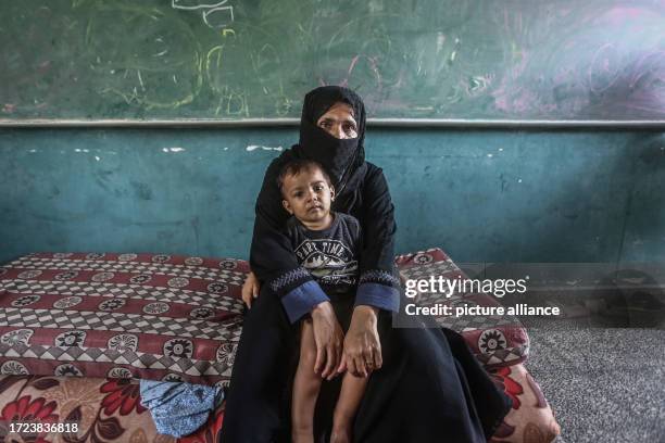 October 2023, Palestinian Territories, Khan Yunis: A displaced Palestinian woman and her little kid seek refuge in UN school in Khan Yunis, as...