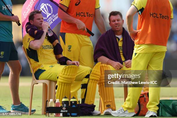 David Warner and Steve Smith of Australia take a drinks break due to the humidity and heat during the ICC Men's Cricket World Cup India 2023 between...