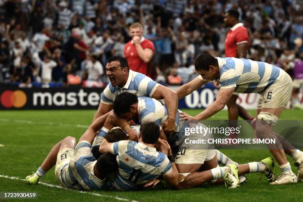 Argentina's players including hooker Agustin Creevy embrace Argentina's fly-half Nicolas Sanchez after he scored an interception try during the...