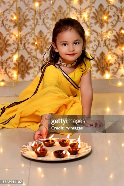 small baby girl celebrating diwali festival at home - indian dish stock pictures, royalty-free photos & images