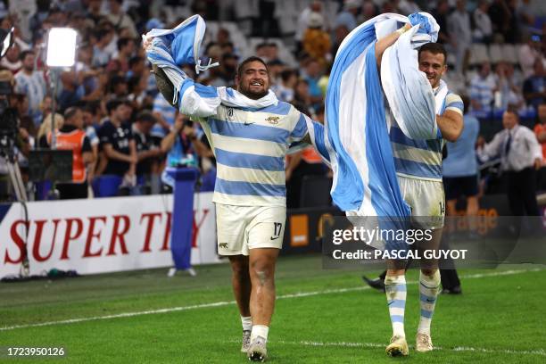 Argentina's prop Joel Sclavi and Argentina's right wing Emiliano Boffelli carry a giant national flag of Argentina as they celebrate their victory at...