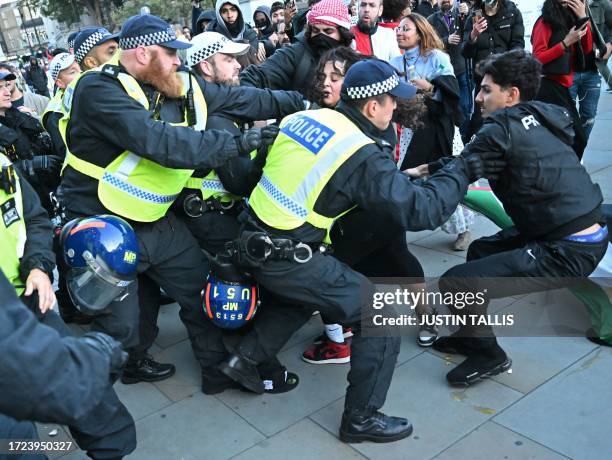 Police officers make an arrest in Trafalgar Square after a 'March For Palestine', part of a pro-Palestinian national demonstration, in London on...