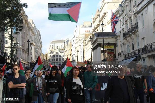 People carry Palestinian flags and placards as they stage a demonstration in support of Palestinians in London, United Kingdom on October 14, 2023.
