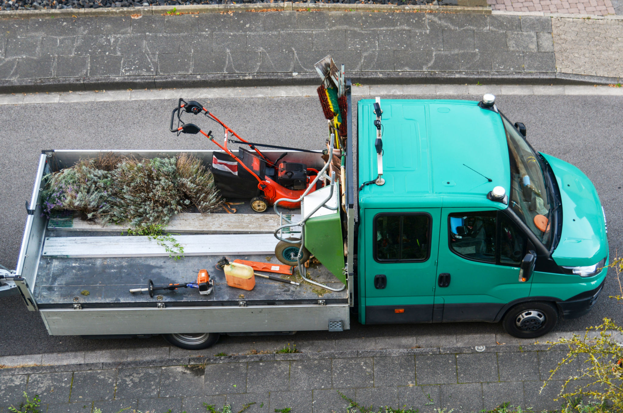 Lawnmower, wheelbarrow, broom, rake, shovels, and other tools for home and garden on the bed of a truck Lawnmower, wheelbarrow, broom, rake, shovels, and other tools for home and garden on the bed of a truck