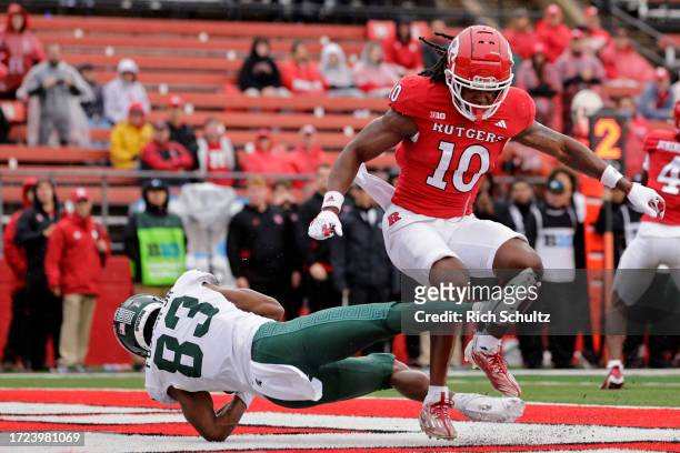 Wide receiver Montorie Foster Jr. #83 of the Michigan State Spartans makes a catch for a touchdown as defensive back Flip Dixon of the Rutgers...
