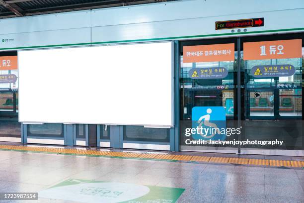 on the wall of a subway station, a blank billboard advertising banner media display - subway platform poster stock pictures, royalty-free photos & images