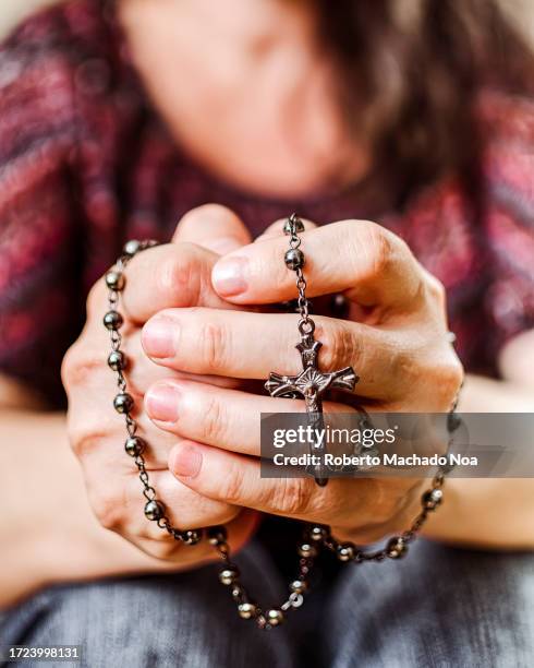 rosary in hands of woman - gebetskette stock-fotos und bilder