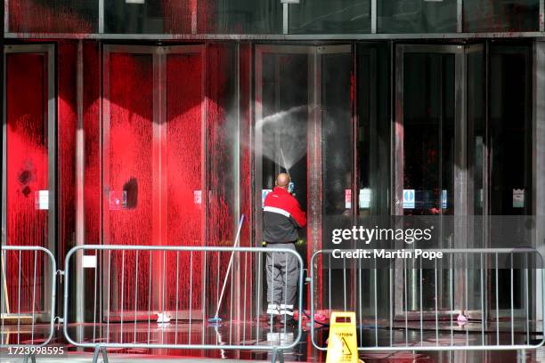 Workers start to clean the paint off the building with a power washer and squeegee on October 14, 2023 in London, England. Palestine Action activists...