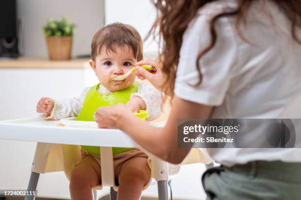 a 6 months old baby girl taking her meal - 6 11 maanden stockfoto's en -beelden