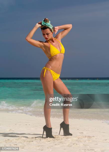 young woman wearing high heels on beach - ブーティ ストックフォトと画像