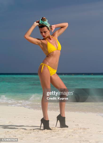 young woman wearing high heels on beach - shoe boot stock pictures, royalty-free photos & images