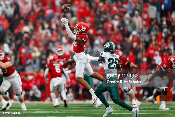 Wide receiver Ian Strong of the Rutgers Scarlet Knights attempts to catch a pass that gets intercepted by defensive back Chance Rucker of the...