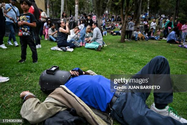 Man uses a welding mask to watch the annular solar eclipse in Bogota on October 14, 2023. Skygazers across the Americas turned their faces upwards...