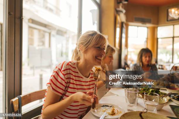 a young woman eating in a restaurant - brunch imagens e fotografias de stock