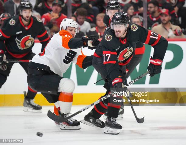 Zack MacEwen of the Ottawa Senators battles for puck possession against Morgan Frost of the Philadelphia Flyers at Canadian Tire Centre on October...