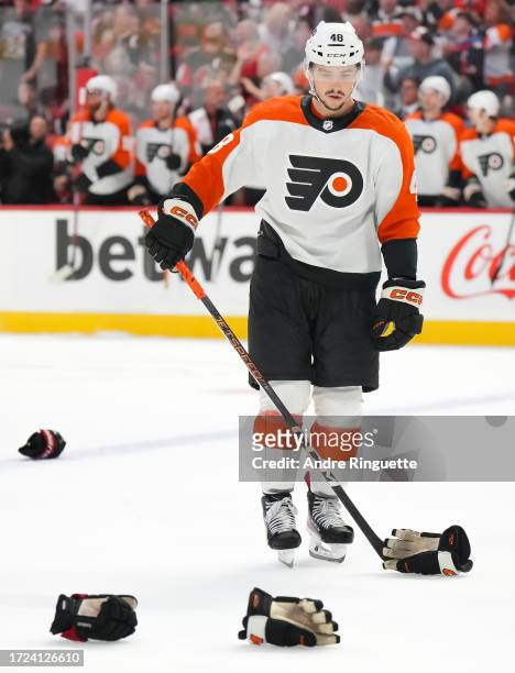 Morgan Frost of the Philadelphia Flyers collects the gloves of team-mate Nick Seeler after his fight with Mark Kastelic of the Ottawa Senators at...