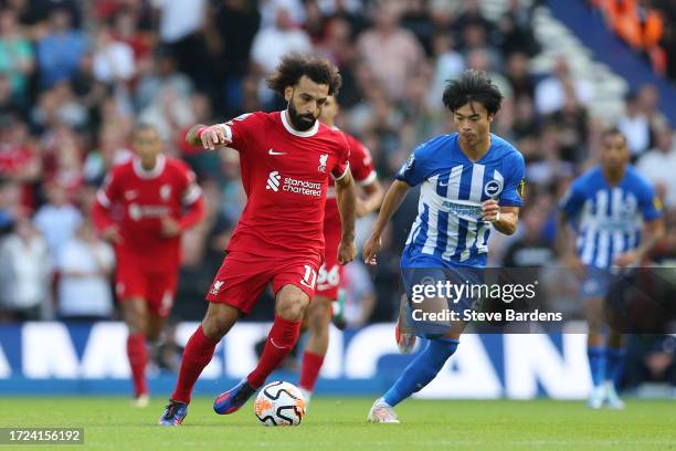 Mohamed Salah of Liverpool runs with the ball whilst under pressure from Kaoru Mitoma of Brighton & Hove Albion during the Premier League match...