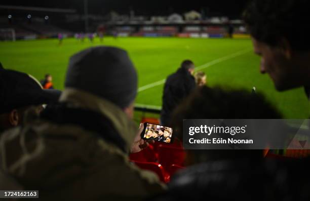 Paris , France - 14 October 2023; Supporters gather to watch the Rugby World Cup match between Ireland and New Zealand on a phone in the stands...