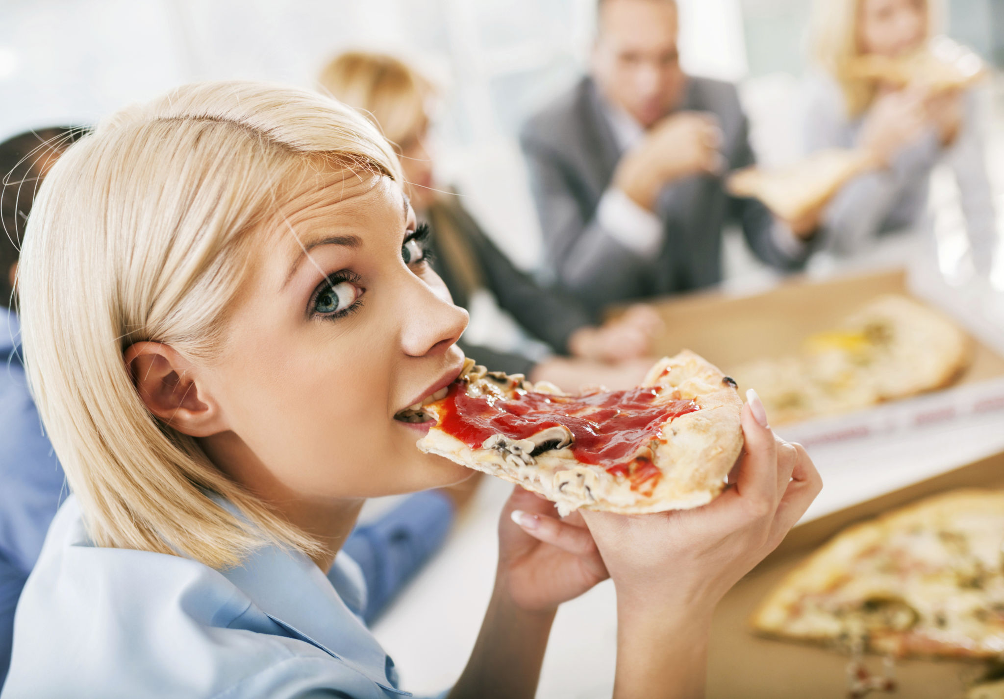 Businesswoman eating pizza on a meeting. Businesswoman eating pizza on a meeting.