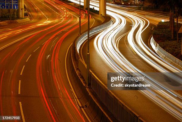 a highway with vehicles moving and blurred - merging sign stockfoto's en -beelden