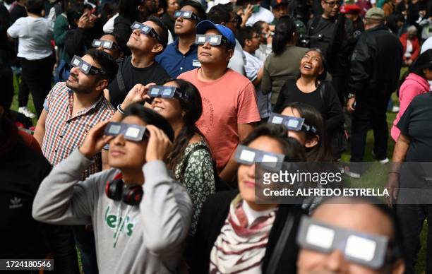 People watch the annular solar eclipse at the Luis Enrique Erro Planetarium of the National Polytechnic Institute in Mexico City on October 14, 2023....