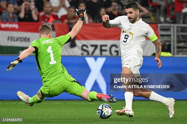 Serbia's forward Aleksandar Mitrovic gets through on Hungary's goalkeeper Denes Dibusz' goal but fails to score during the UEFA Euro 2024 Group G...