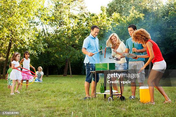 cheerful families barbecue outdoors. - bbq smoker stock pictures, royalty-free photos & images