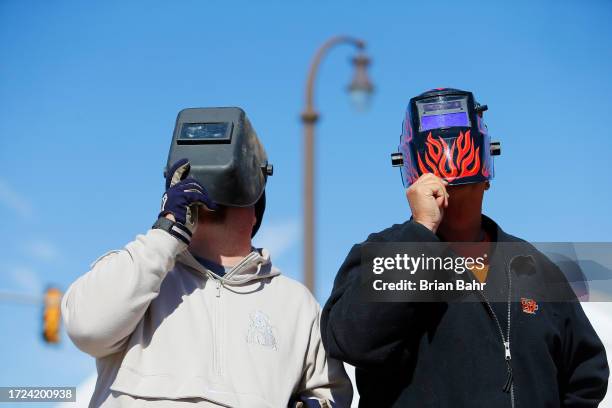 Oklahoma State Cowboys fans watch the solar eclipse through a welding helmet before a game against the Kansas Jayhawks at Boone Pickens Stadium on...