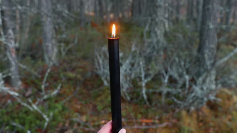 https://media.gettyimages.com/id/1724205154/video/woman-holding-a-black-candle-in-the-forest-during-halloween-twilight.jpg?b=1&s=640x640&k=20&c=9G-AbZB234QWs4uiD21NGVfik5imz1uA3PaXz61y6KM=
