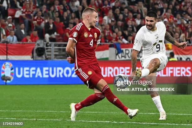 Serbia's forward Aleksandar Mitrovic shoots past Hungary's defender Adam Szalai during the UEFA Euro 2024 Group G qualification football match...