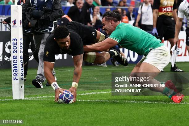 New Zealand's number eight Ardie Savea dives across the line to score a try during the France 2023 Rugby World Cup quarter-final match between...