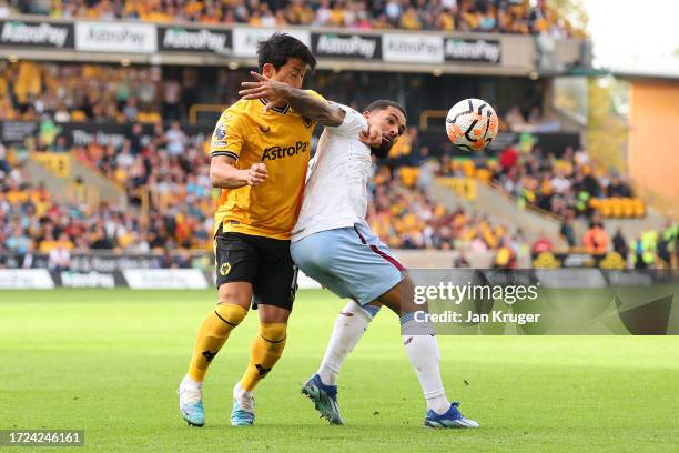 Douglas Luiz of Aston Villa is challenged by Hwang Hee-Chan of Wolverhampton Wanderers during the Premier League match between Wolverhampton...