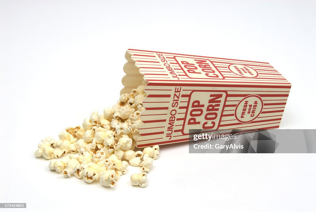 Popcorn spilling from red and white popcorn box-isolated on white