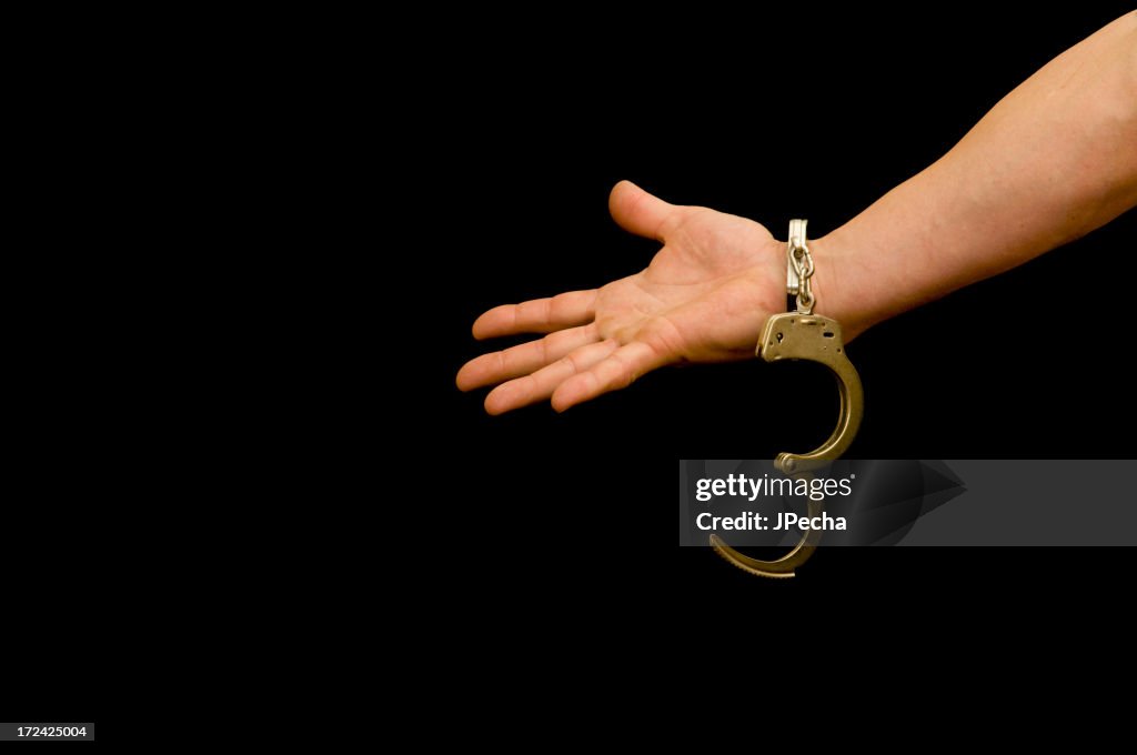 Handcuffed arm, Reaching out over black background